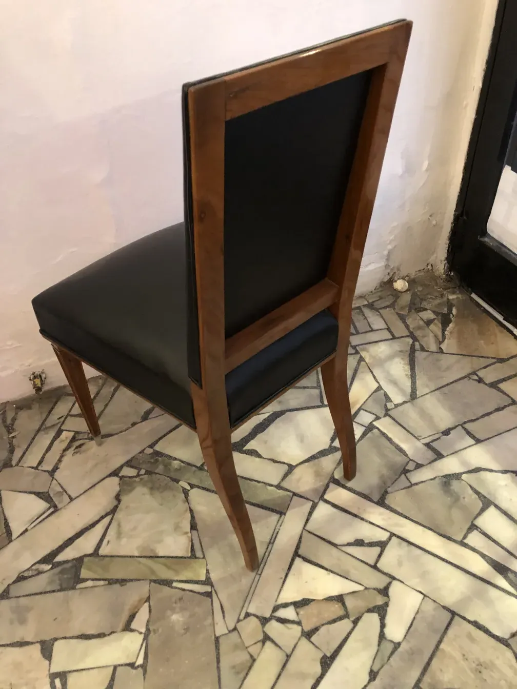 Vue latérale de 12 chaises anciennes sur un sol en pierre clair