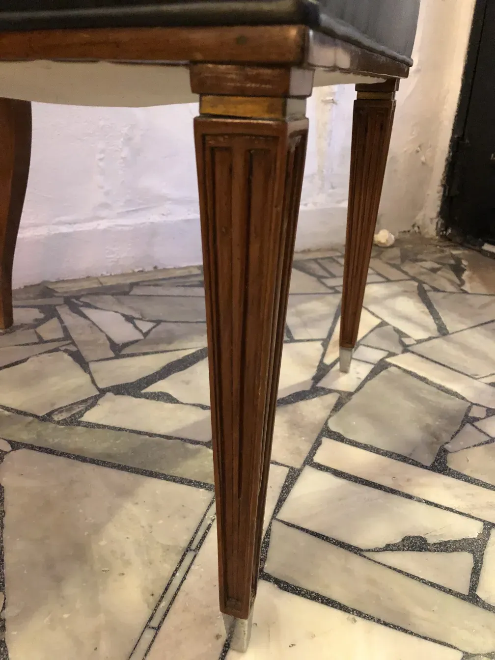 12 cadeiras antigas com pernas elegantes em um piso de pedra