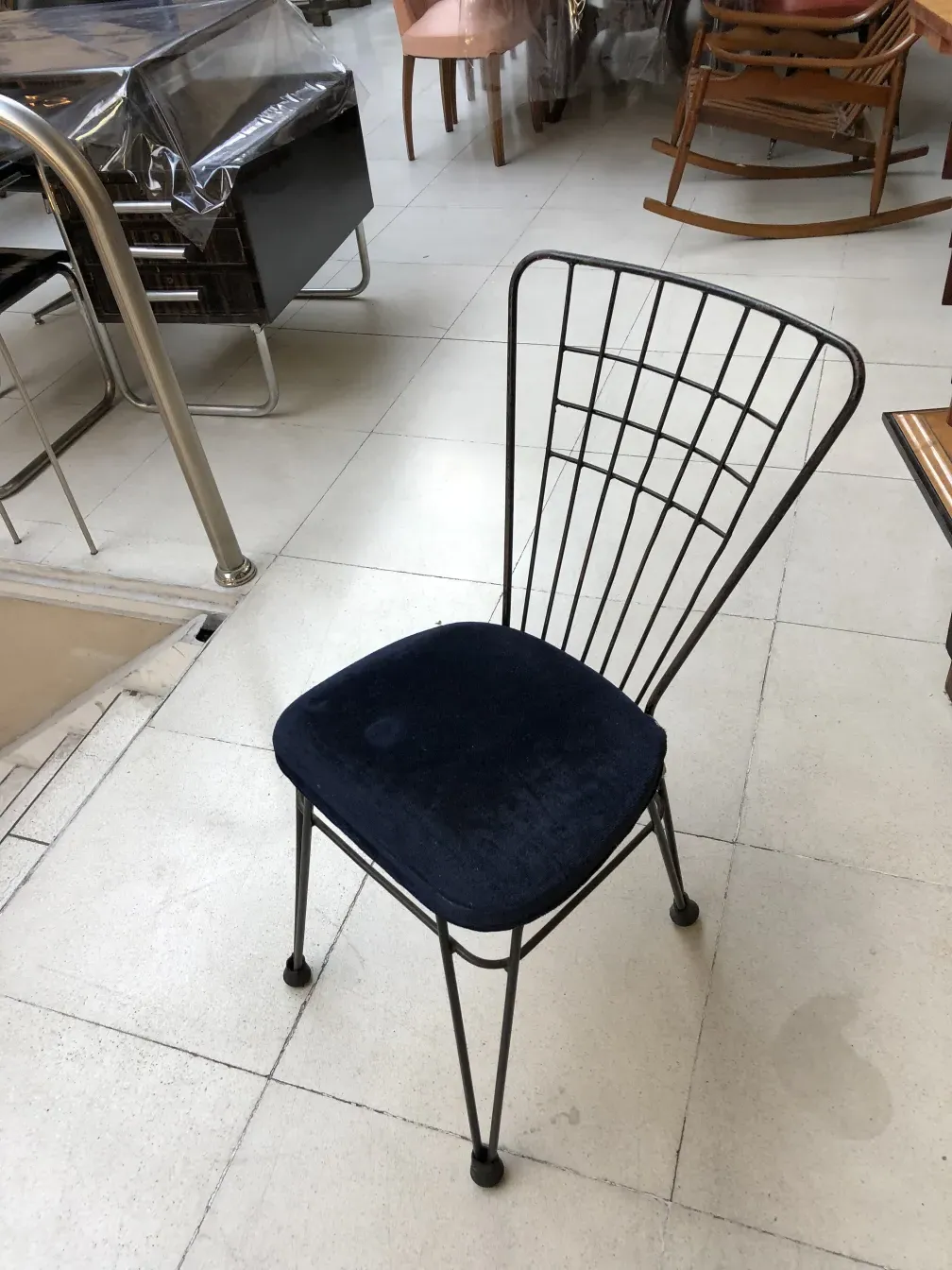 sedia di design antico con seduta blu in un negozio di antiquariato