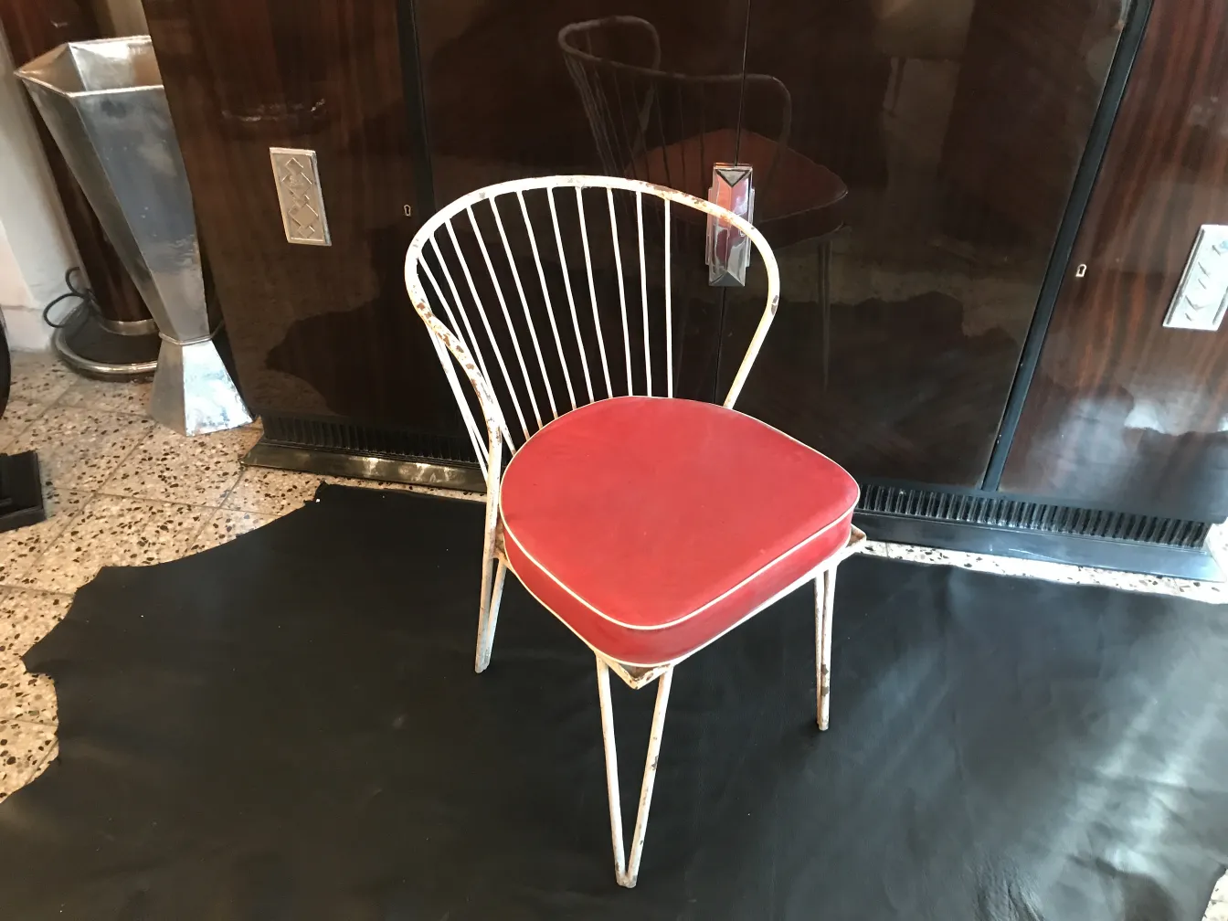 Silla de jardín antigua con cojín rojo, ambiente moderno.