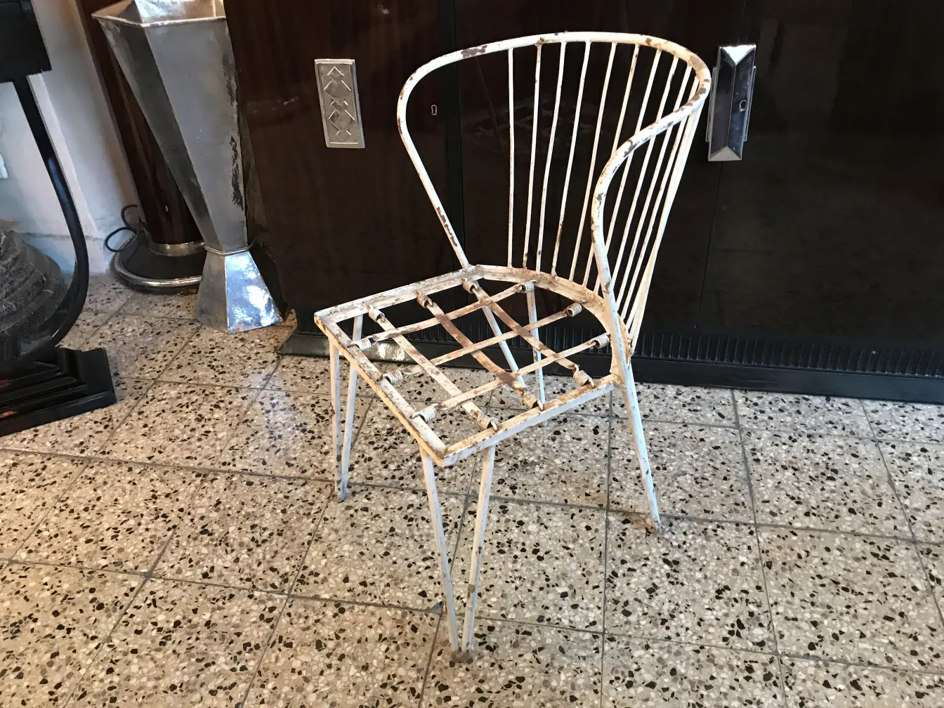 Silla de jardín antigua con un diseño de barandas, en un ambiente clásico.