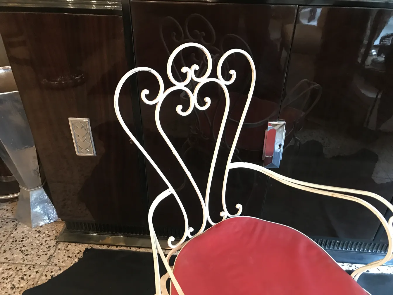 Sillón de jardín antiguo con diseño elegante y detalles coloridos, en un ambiente acogedor y decorativo.