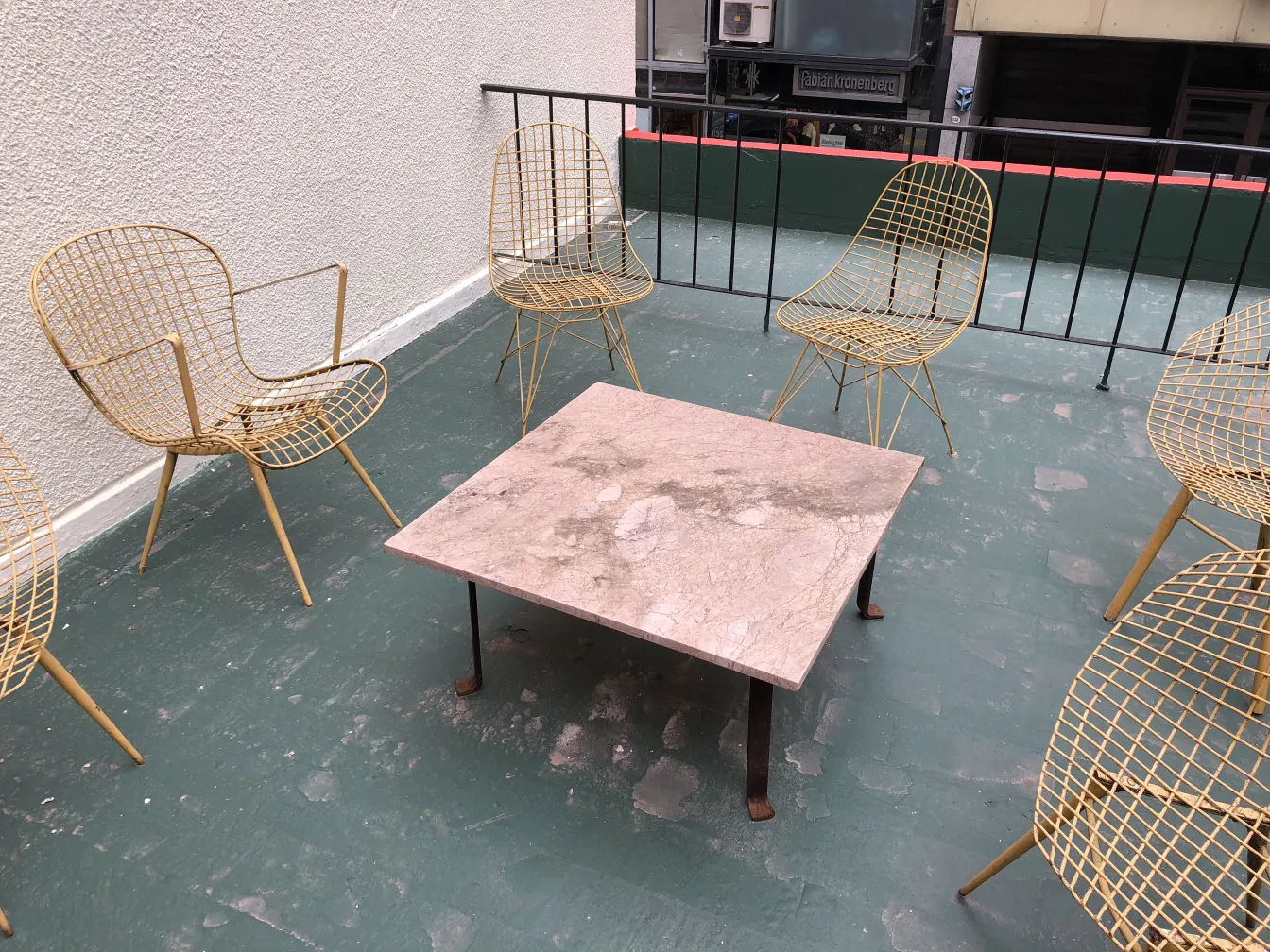 Two antique garden armchairs on a terrace with a table