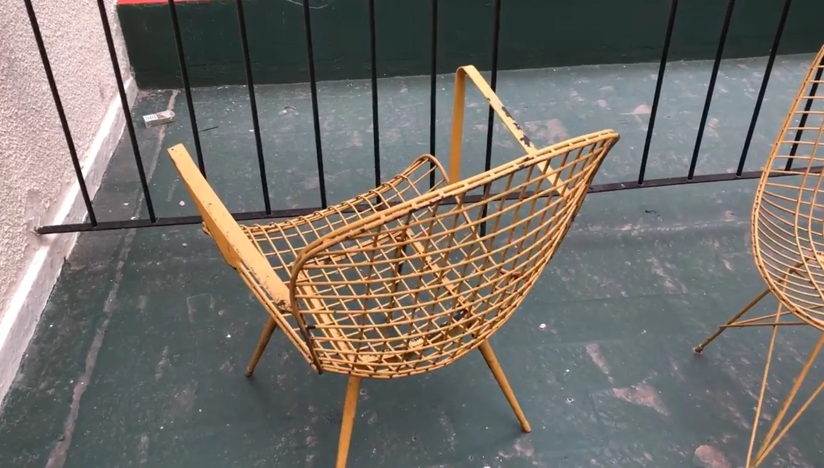 Deux fauteuils de jardin anciens jaunes sur un balcon avec balustrade.