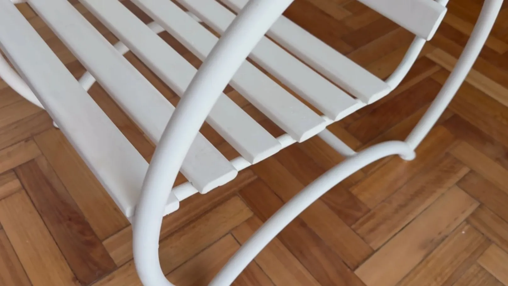 Two antique garden armchairs in white, featuring a simple and elegant design in a cozy setting