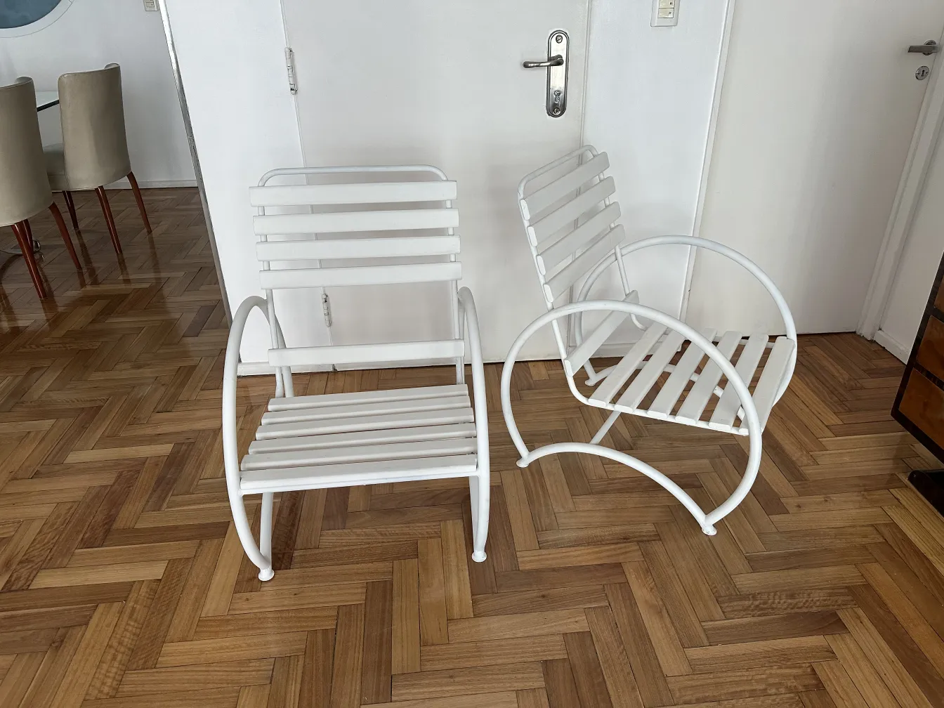 Set di 2 poltrone da giardino antiche bianche, in un ambiente moderno.