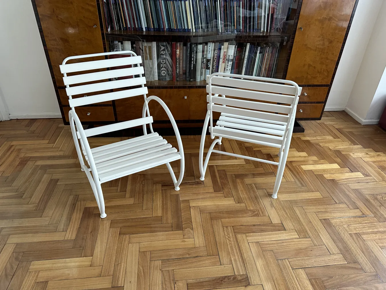 Two antique garden armchairs in a cozy setting, light tones, and an elegant wooden floor.