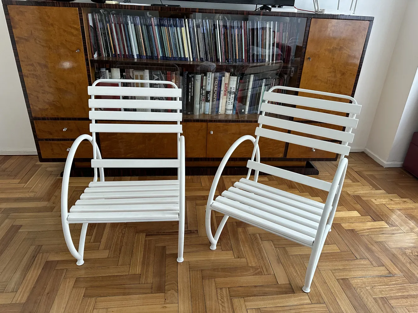 Poltronas de jardim antigas brancas com linhas elegantes em um ambiente aconchegante.