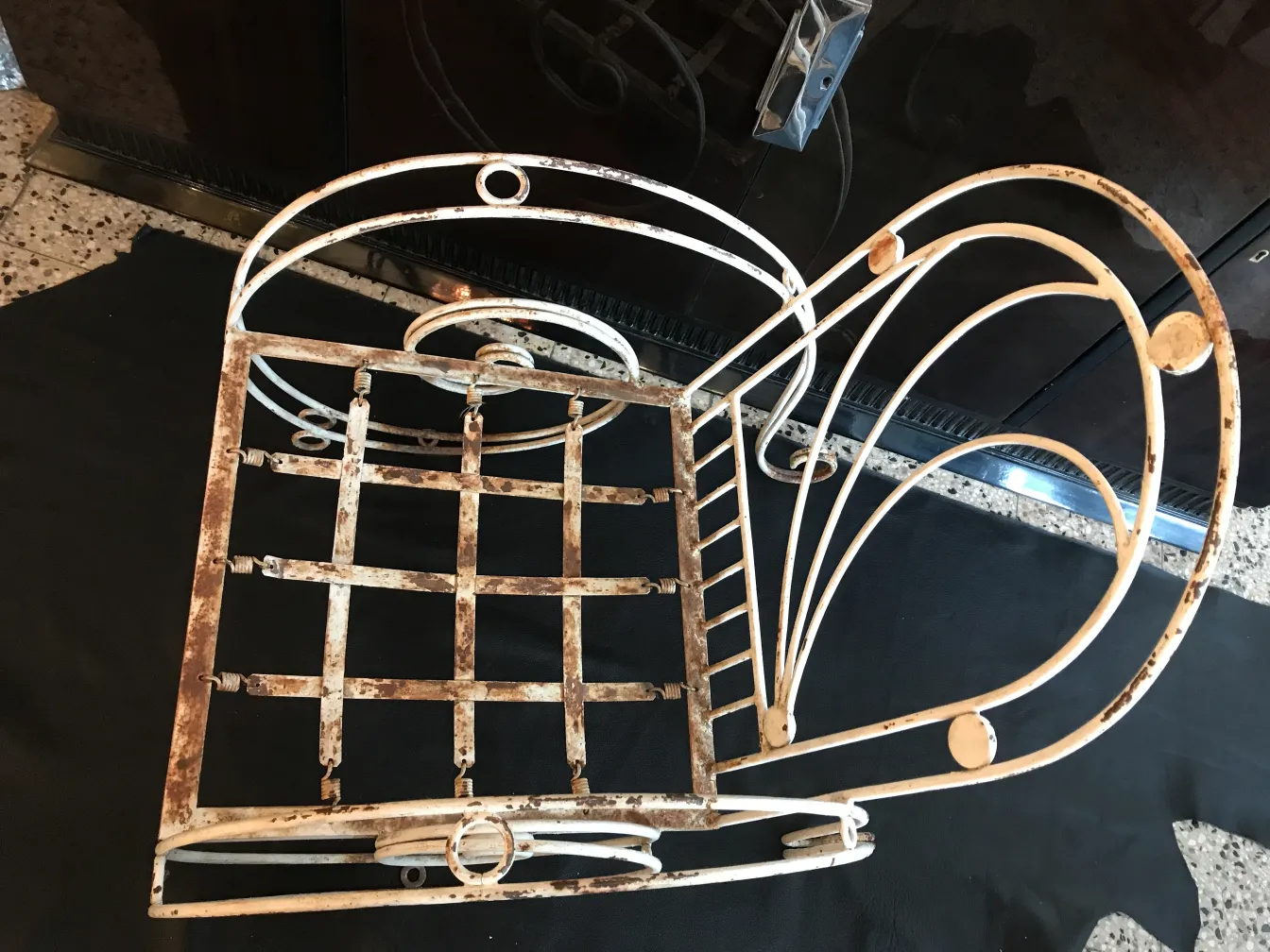 Trois fauteuils de jardin anciens avec des détails usés, dans un cadre accueillant.