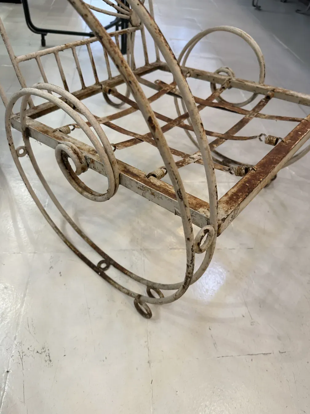 Três poltronas de jardim antigas com curvas delicadas em um ambiente acolhedor.