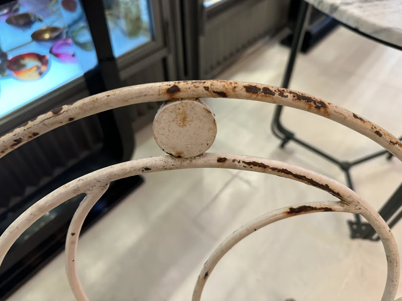 Três poltronas de jardim antigas, com detalhes únicos, em um ambiente acolhedor.