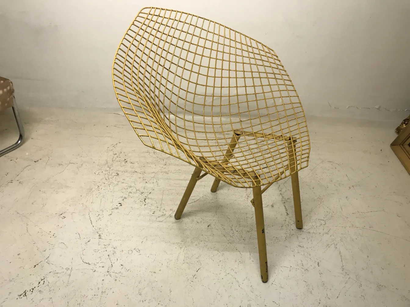 Tres sillones de jardín antiguos con diseño de rejilla amarilla en un ambiente minimalista.