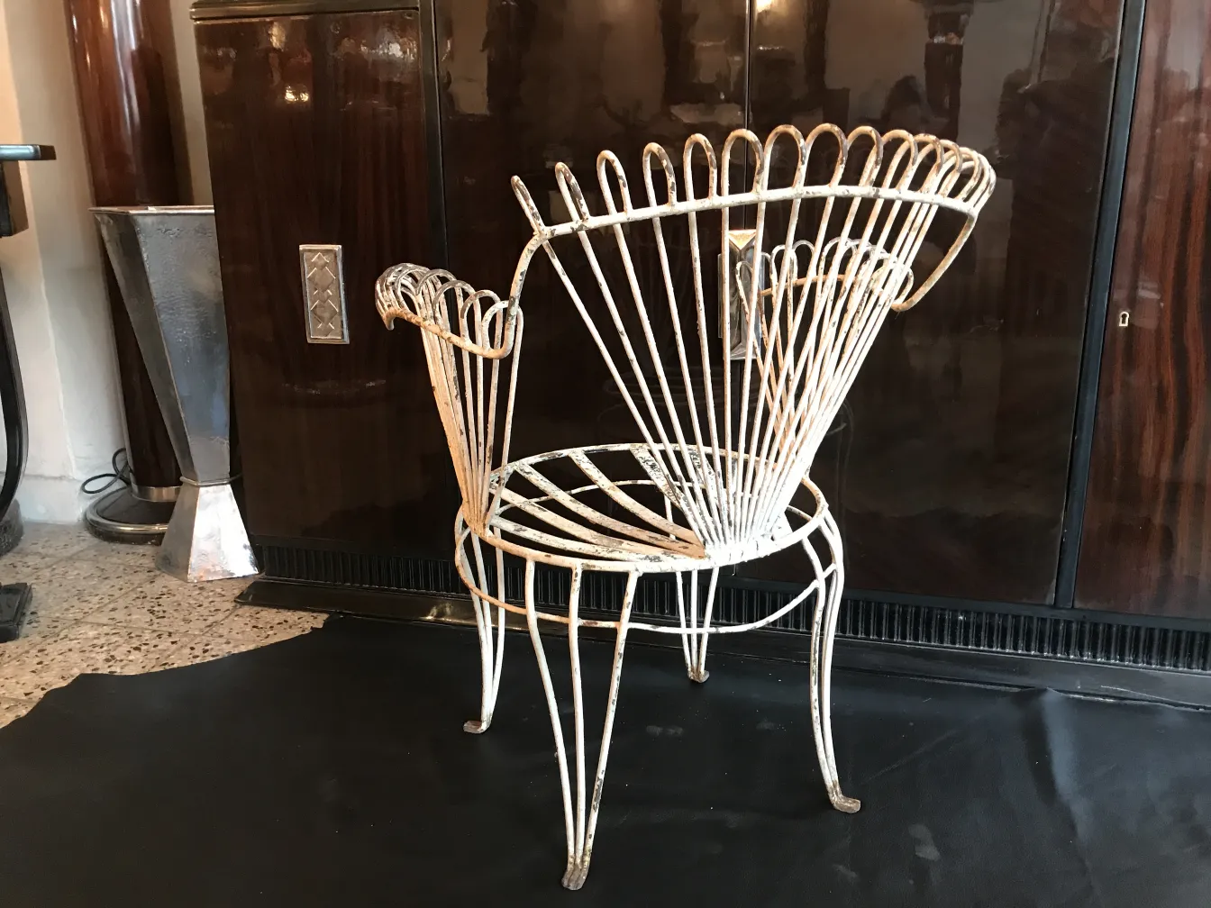 Cuatro sillones de jardín antiguos con diseño distintivo en un ambiente elegante.