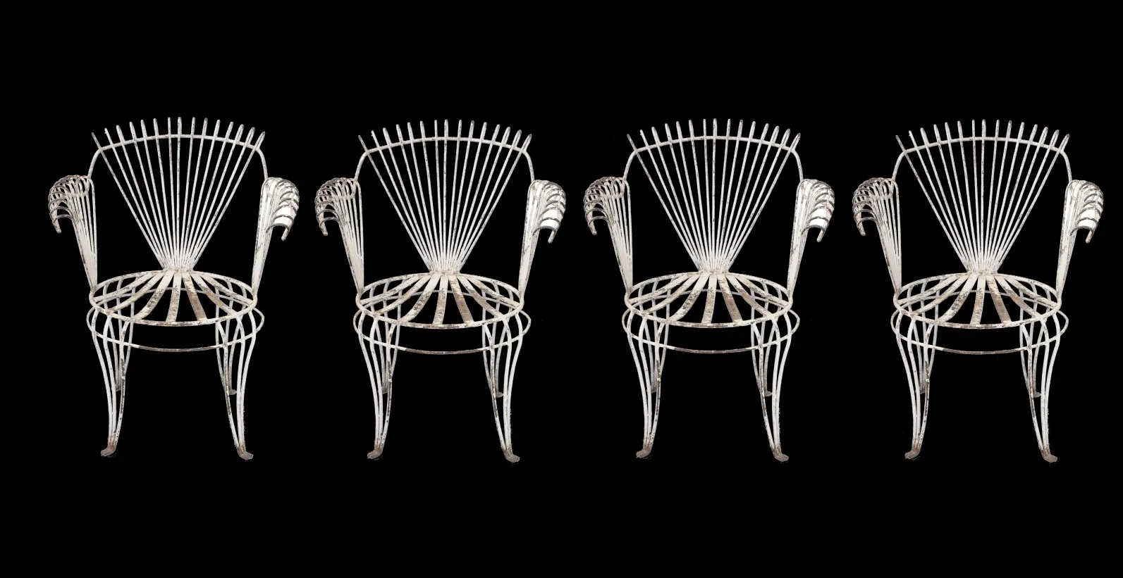 4 antique garden armchairs with a unique design in a dark setting