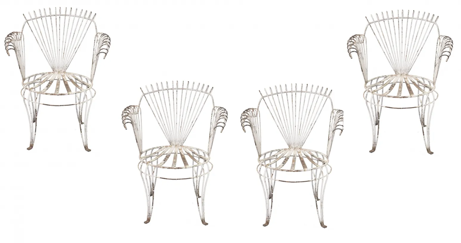 Cuatro sillones de jardín antiguos con un color desgastado, formando un conjunto único en un entorno exterior.