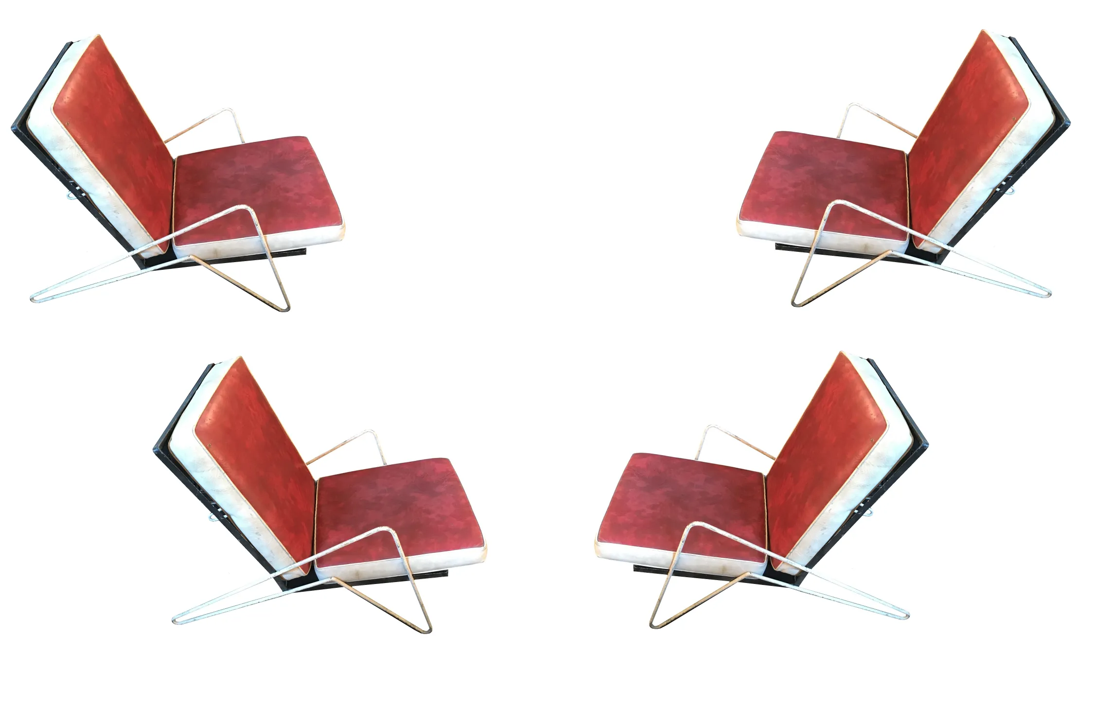 Four antique garden armchairs in red, featuring an appealing design, set in an outdoor environment