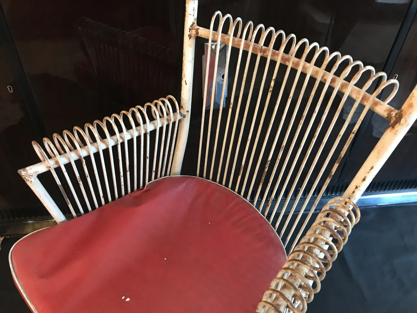 4 fauteuils de jardin anciens avec design classique et couleur rouge, dans un cadre chaleureux