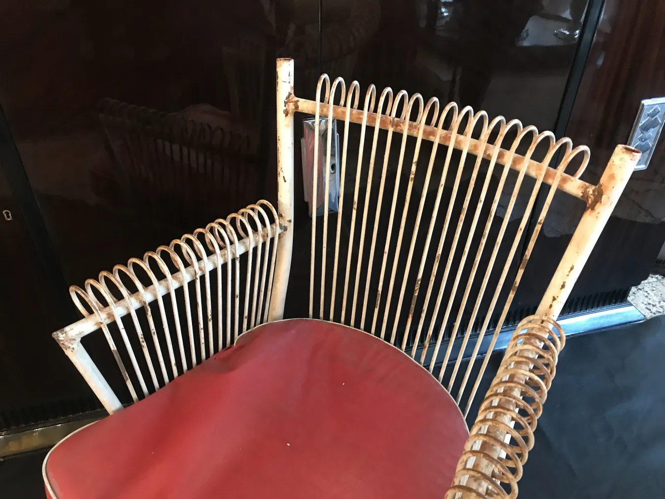 Vue de 4 fauteuils de jardin anciens, avec un design distinctif dans un cadre accueillant.