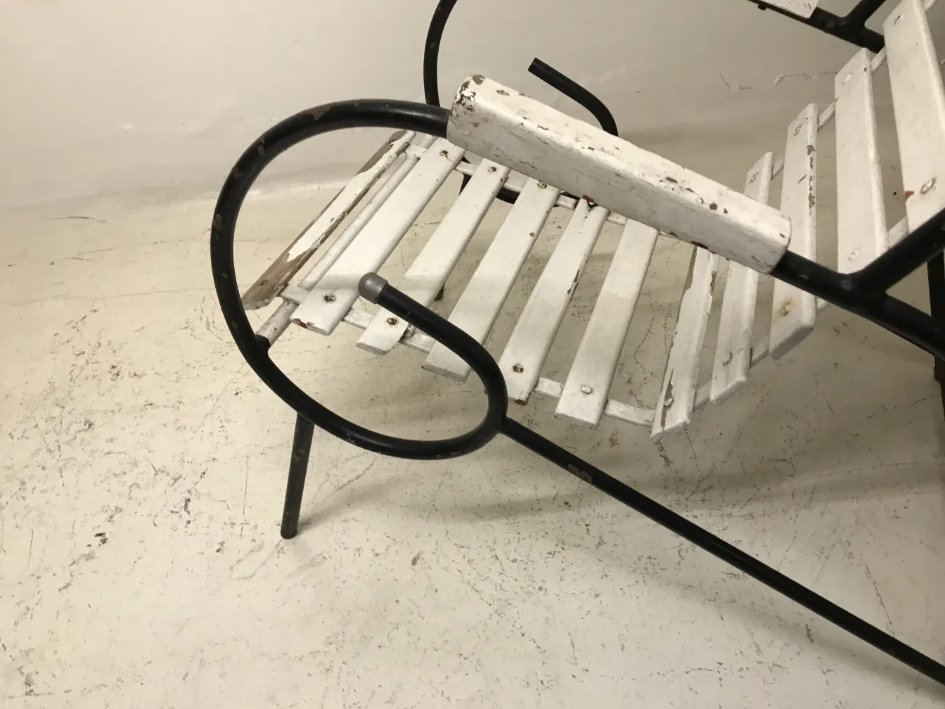 oito poltronas antigas de jardim em um ambiente simples.