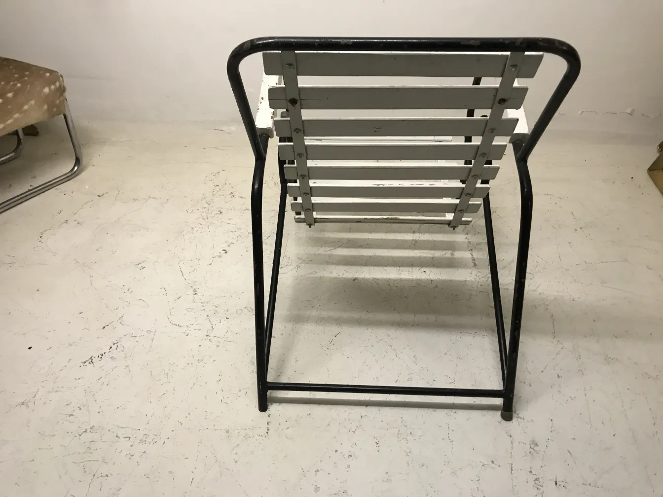 Fauteuils de jardin anciens avec cadre en métal dans un cadre neutre.