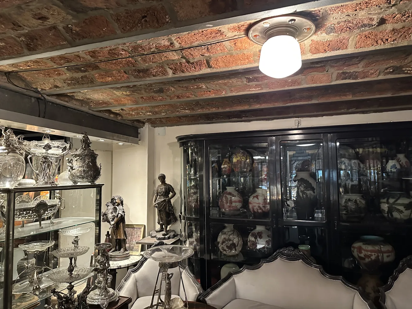 Plafonnier ancien éclairant une pièce avec des meubles décoratifs.