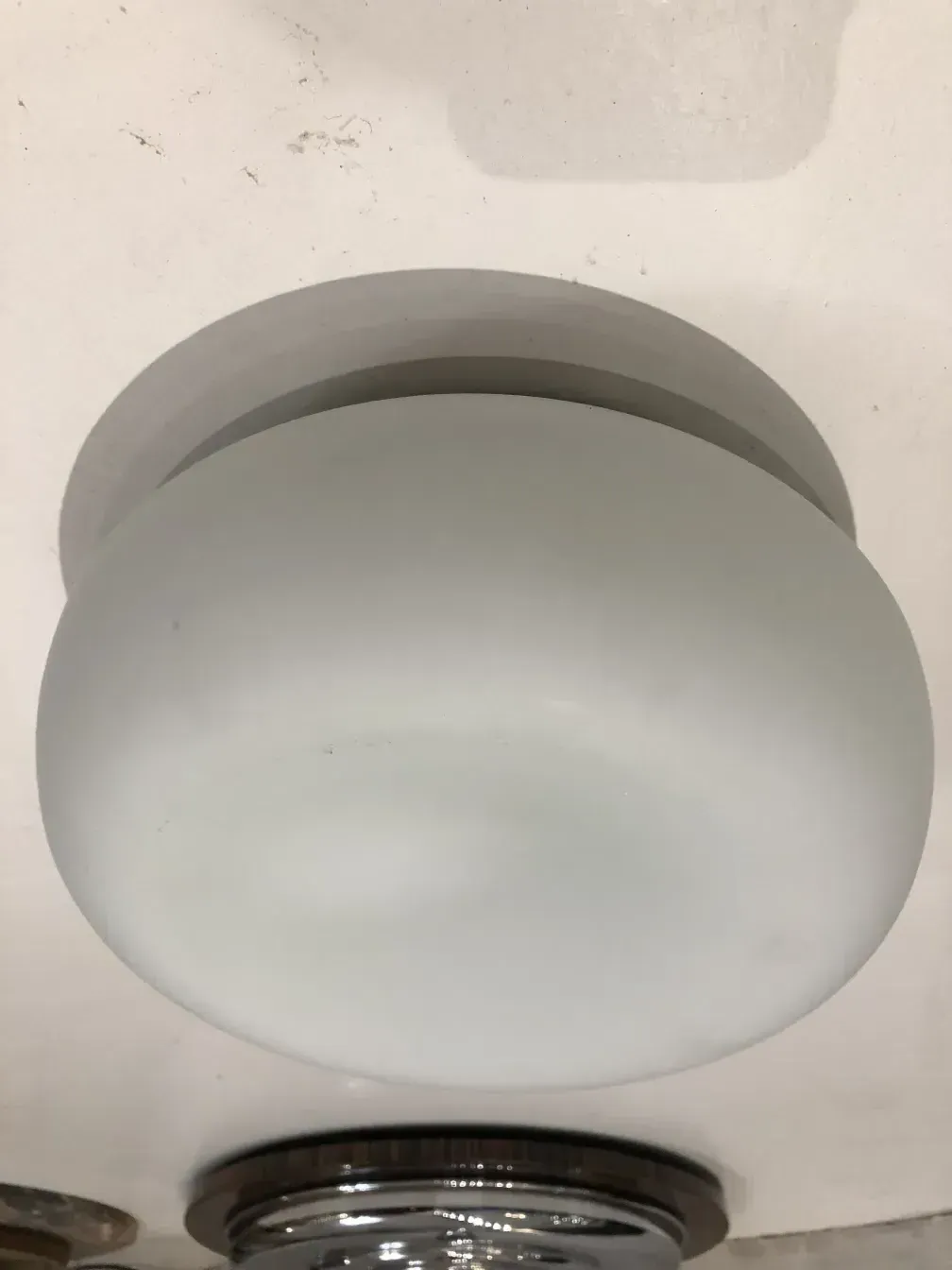 plafonnier ancien rond au design simple dans un cadre sombre