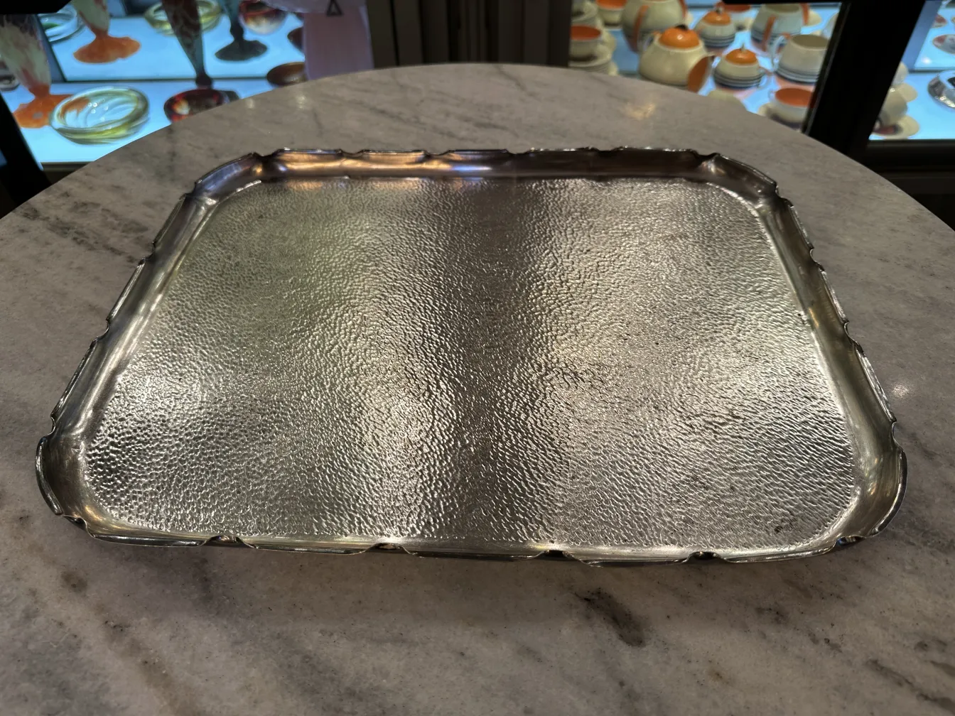 bandeja antiga com bordas decorativas e superfície texturizada