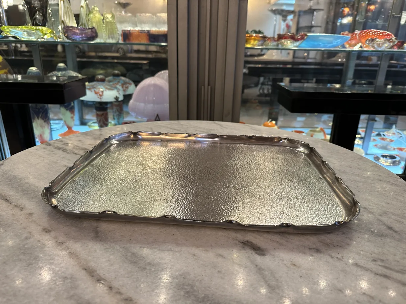 古董托盘，带有光面和波浪边缘，放在大理石桌子上