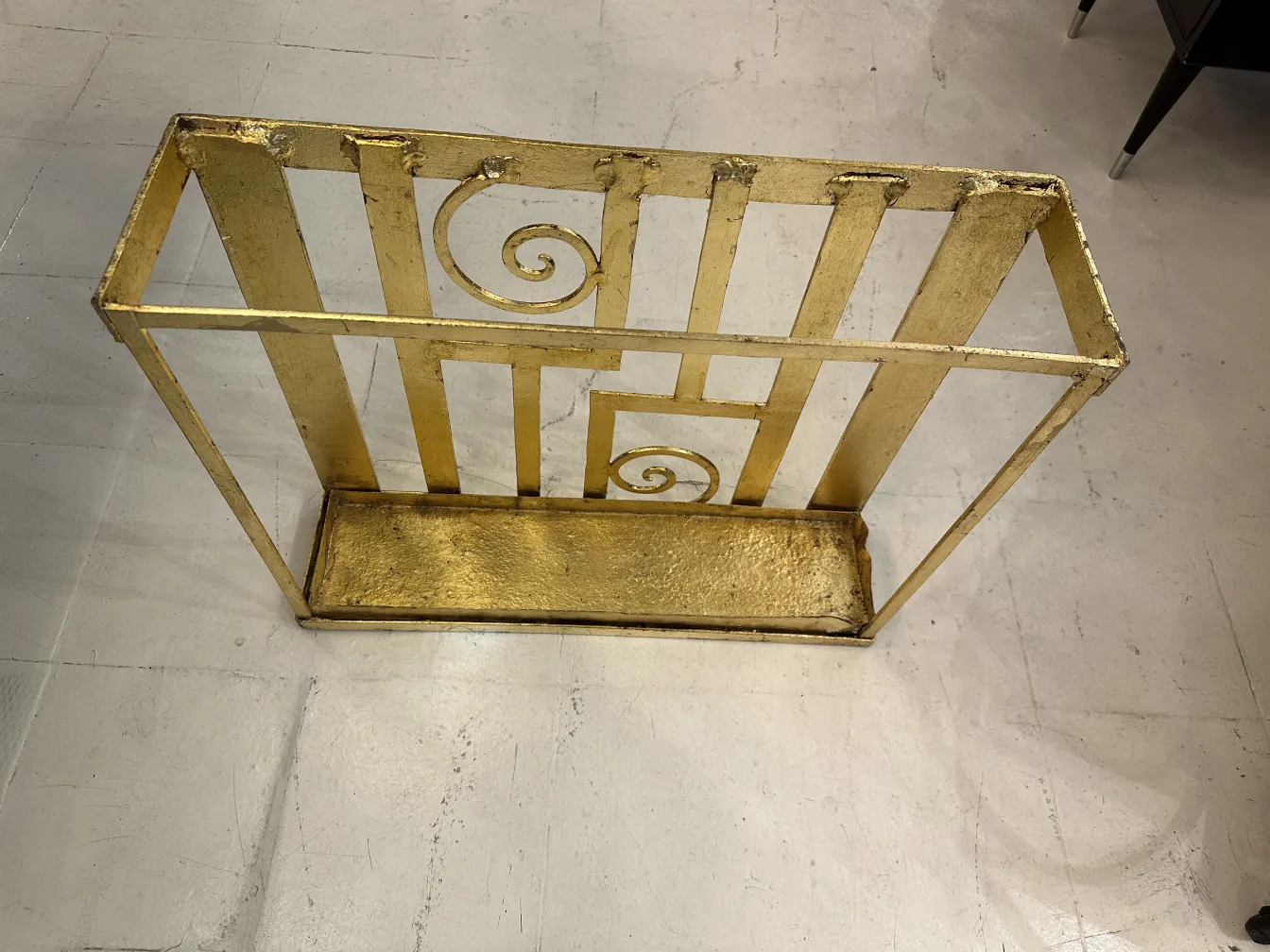 antique umbrella stand with decorative details in gold color