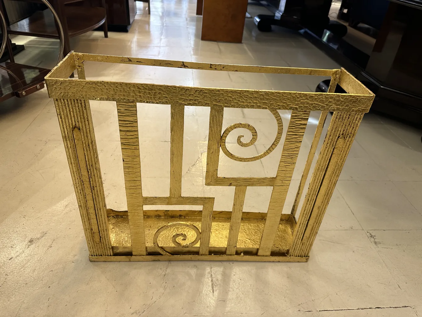 Portaombrelli antico dorato con design a spirale in un ambiente elegante.