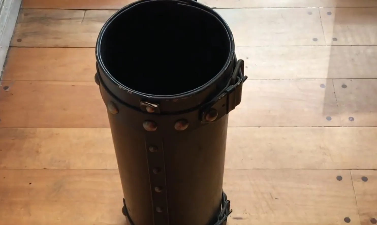 porte-parapluie ancien avec un design distinctif et des détails décoratifs dans un cadre vintage