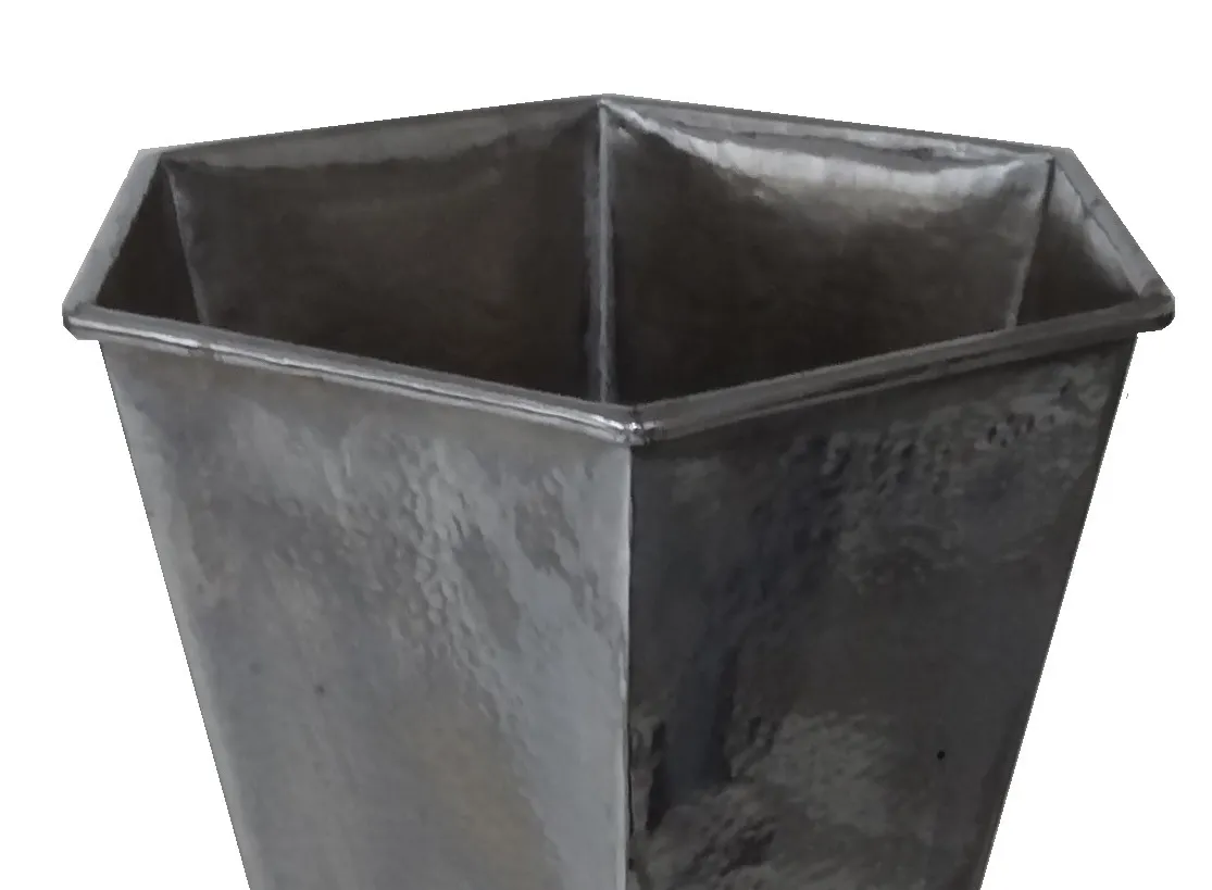 Старая шестигранная подставка для зонтов темного цвета.