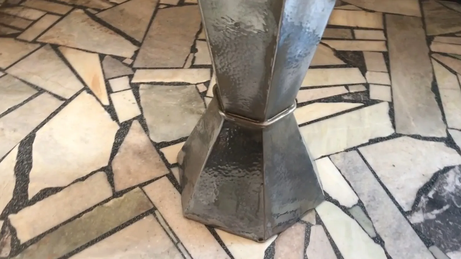 Suporte para guarda-chuva antigo com base decorativa em um ambiente acolhedor