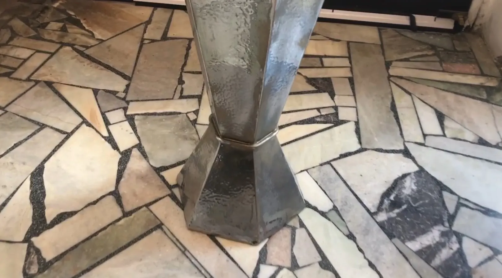 Antique umbrella stand with stylish design on stone floor