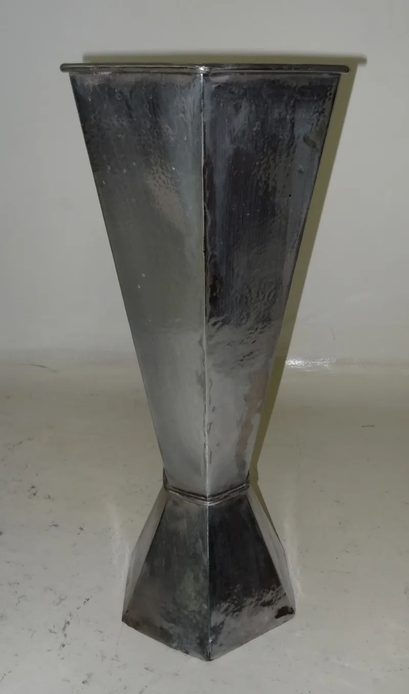 Portaombrelli antico con forma elegante e superficie lucida, in un ambiente neutro.