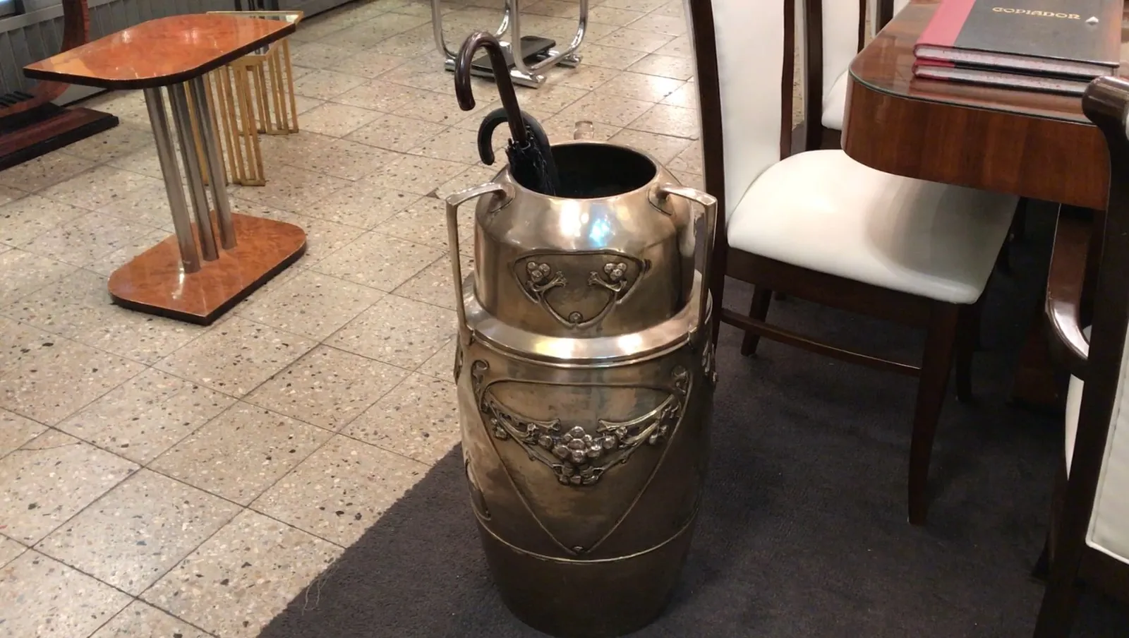 suporte para guarda-chuva antigo com design decorativo, suporta um guarda-chuva. Ambiente elegante.