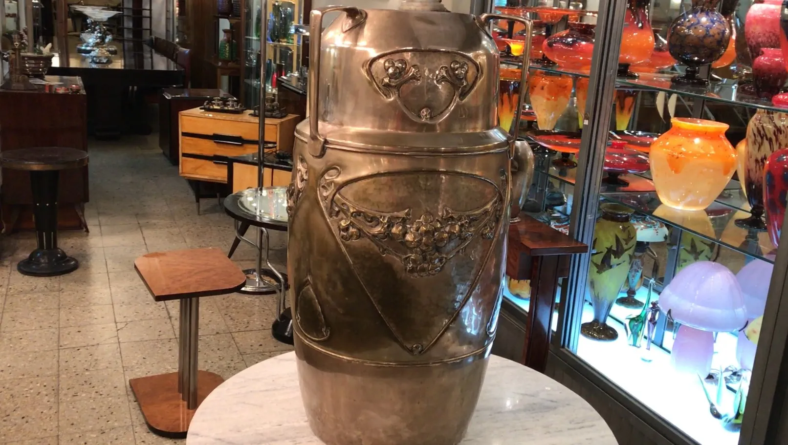 Antiker schirmständer kayser mit dekorativen Details vor antikem Hintergrund.