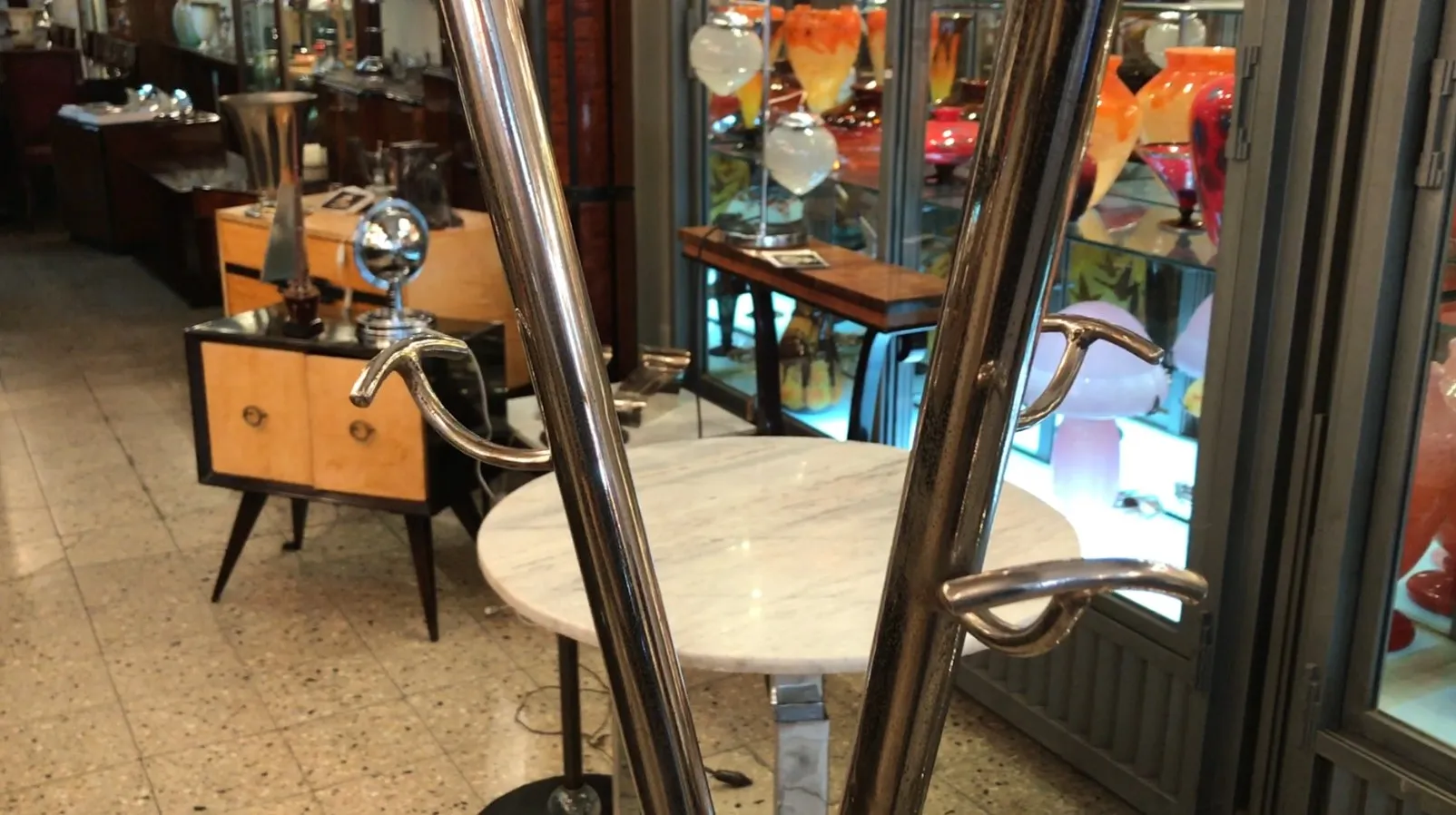 Antique coat rack standing in an antiques environment.