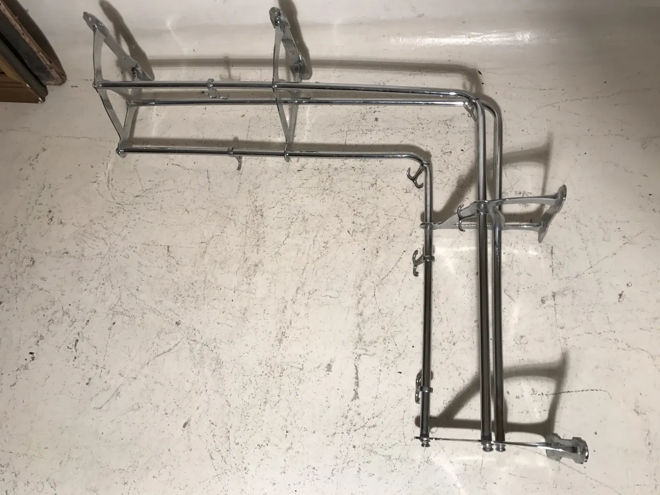 antique coat rack with several hooks against a light background