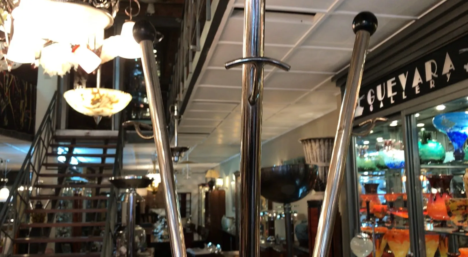 Antique coat rack in a well-lit gallery, with decorative accessories around.
