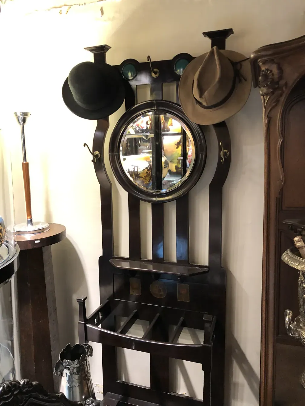 perchero antiguo con sombreros y espejo en un ambiente elegante