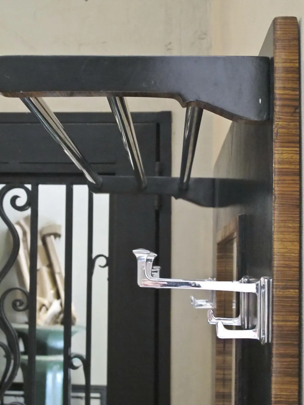 antique coat rack with silver hooks, dark background