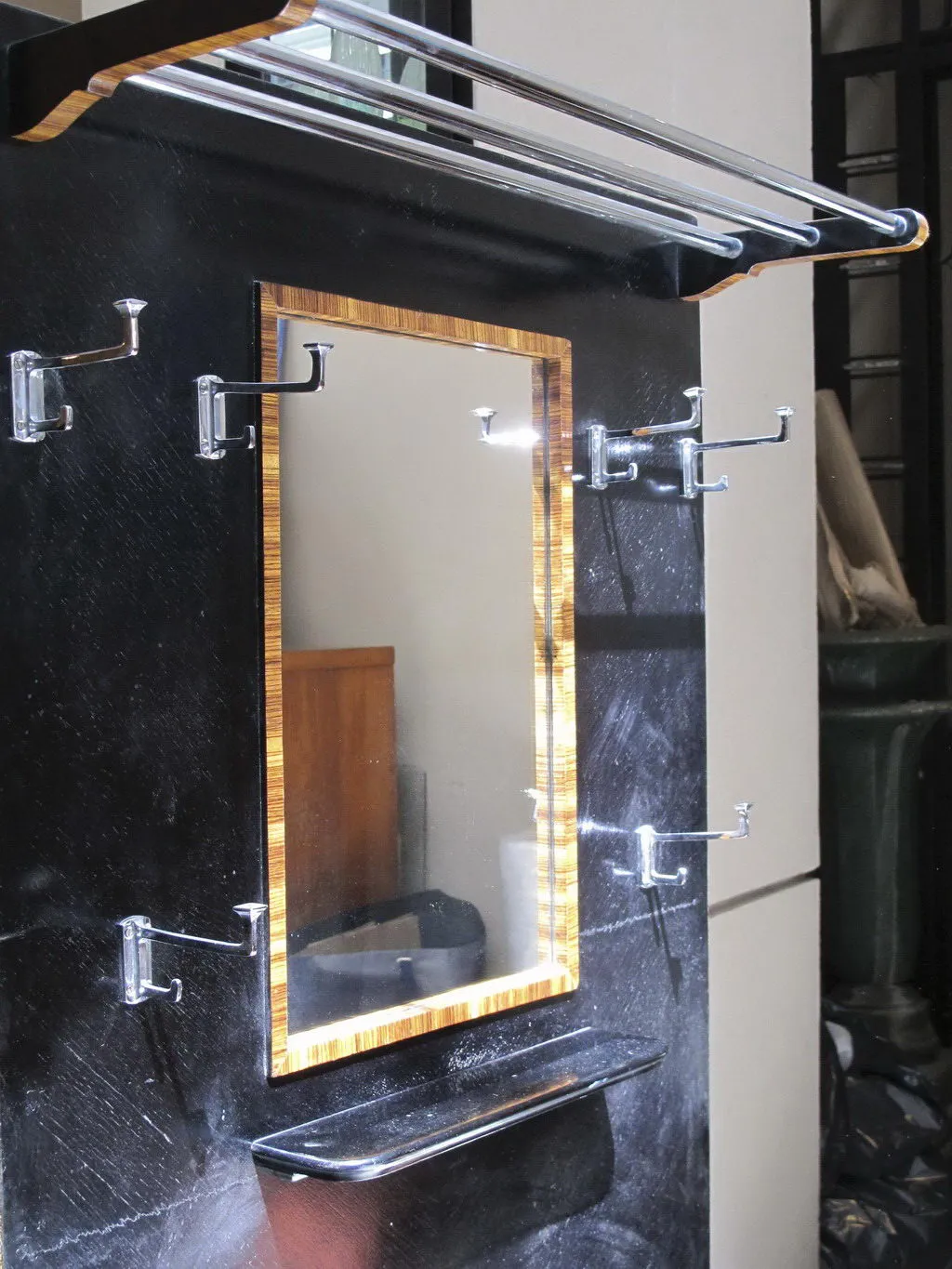 حامل معاطف عتيق مع مرآة وأقواس وخلفية داكنة