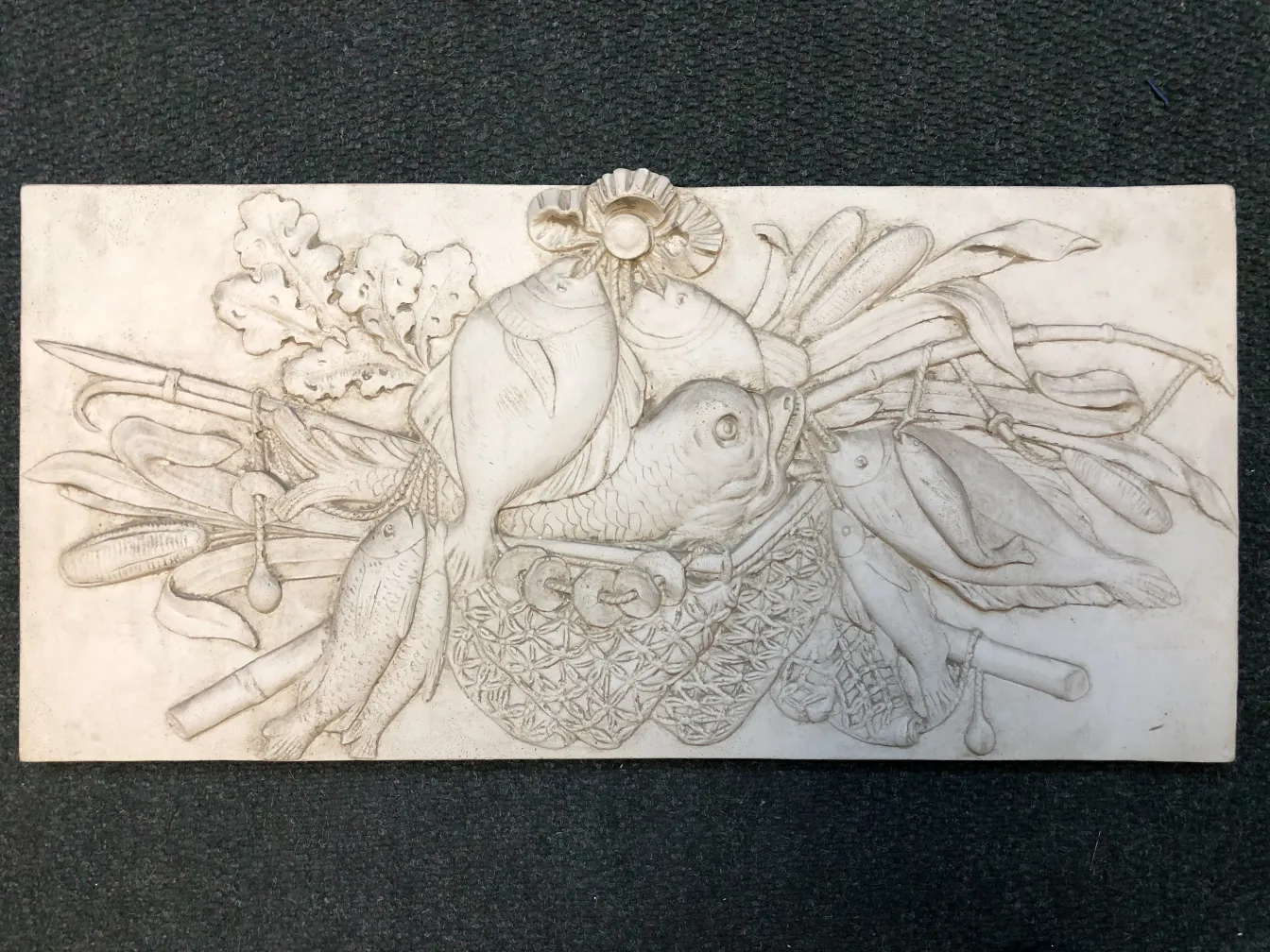 Antique wall plate featuring a fish and vegetable design