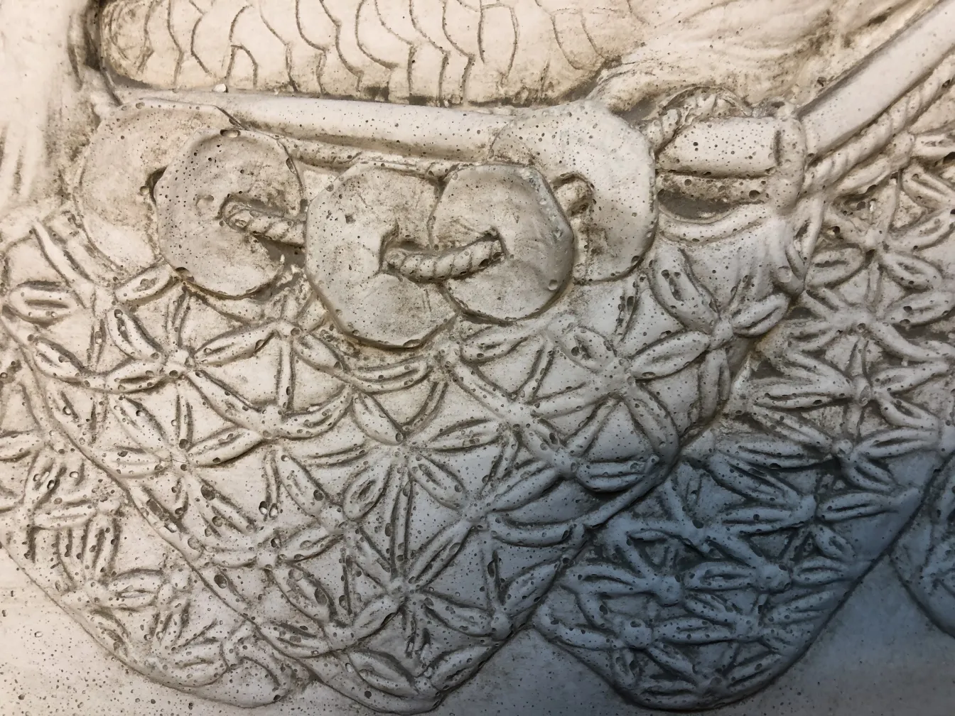 Détail d'une plaque murale ancienne avec un design complexe.