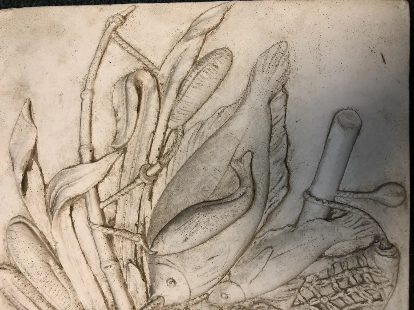 placa de parede antiga com relevo de peixes e vegetação