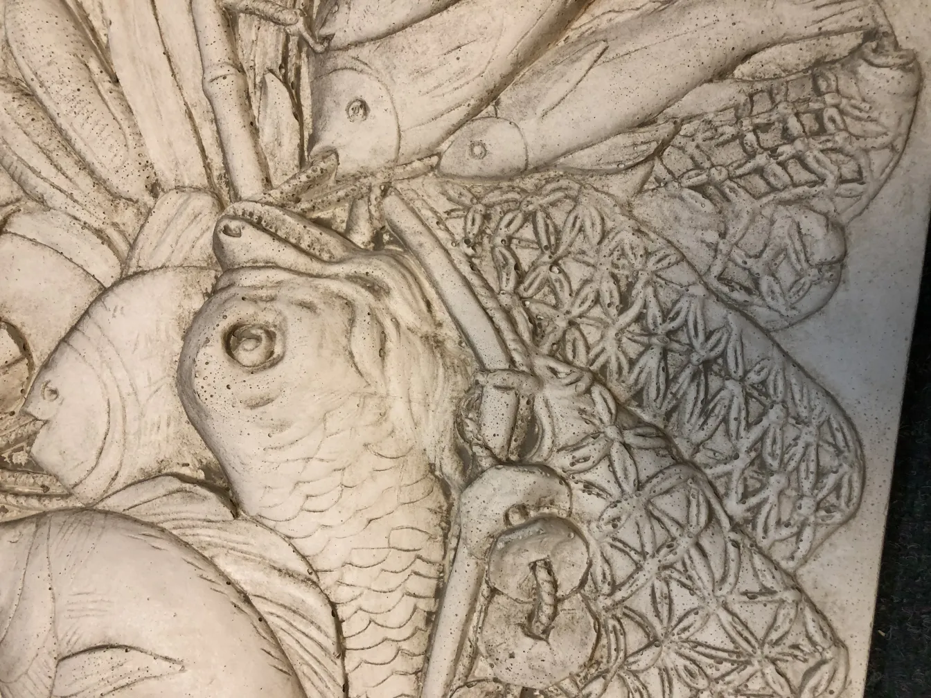 Antica placca a muro con elementi di pesca decorativi