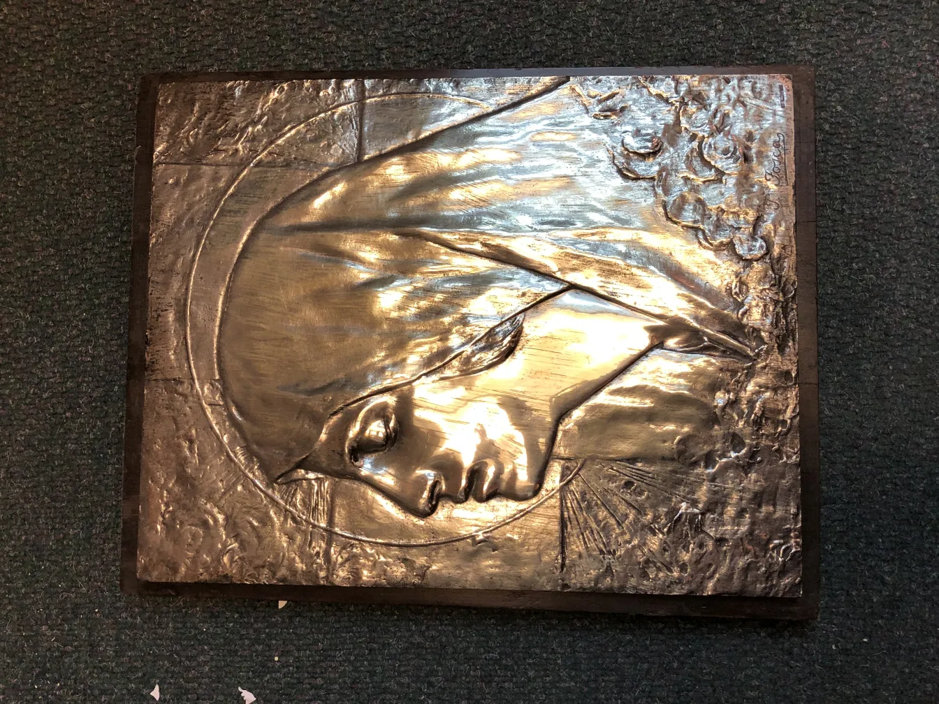 Antique wall plate with a relief of a face