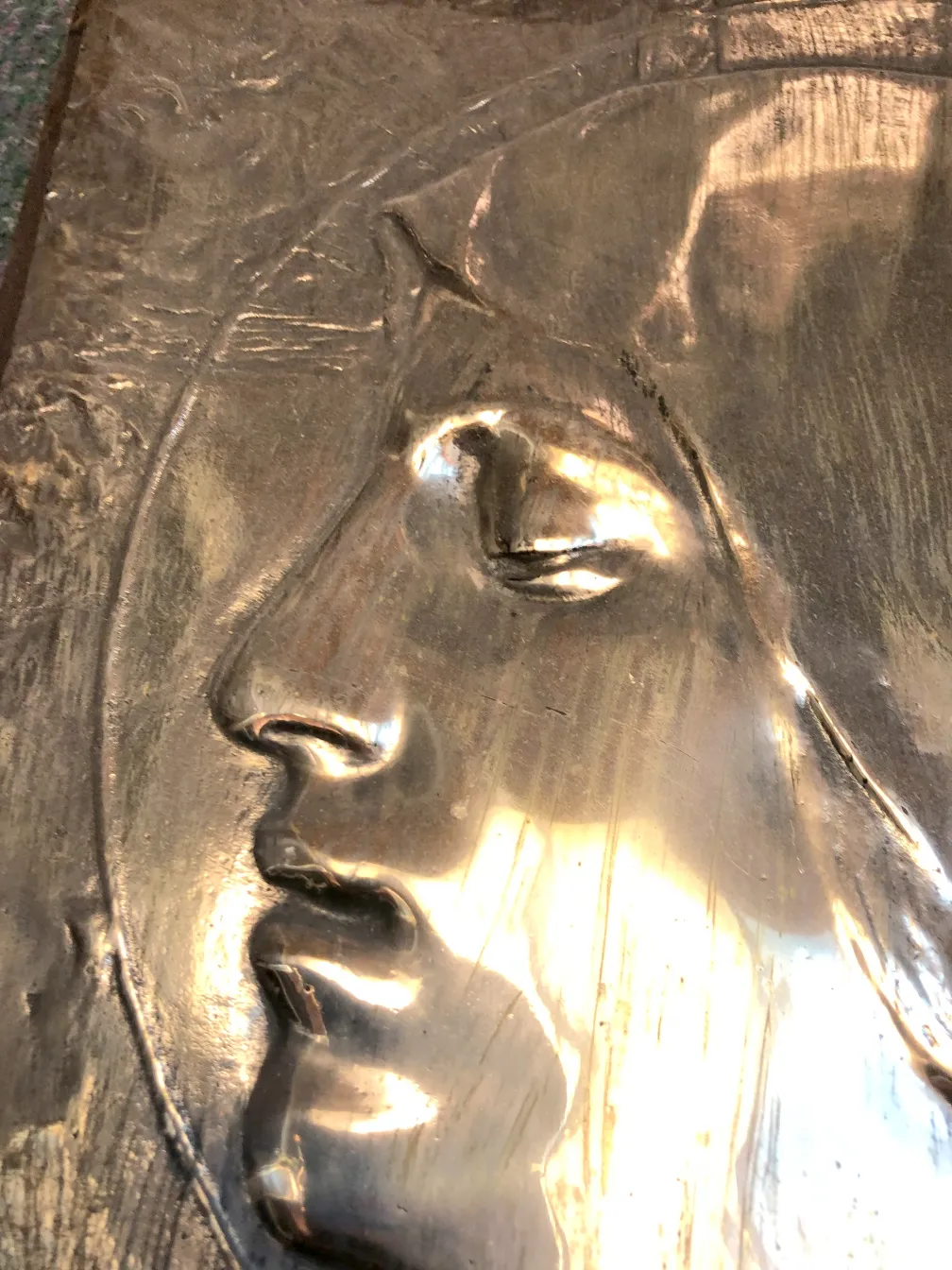 古代金属墙板上有浮雕面孔，温暖的氛围