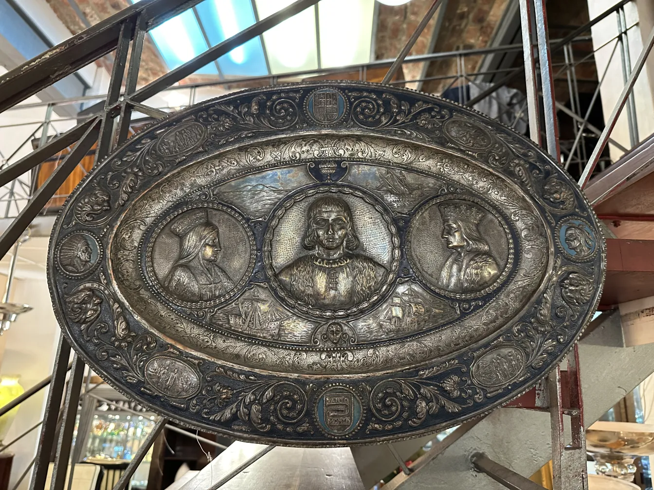 Antique wall plate featuring portraits of figures.